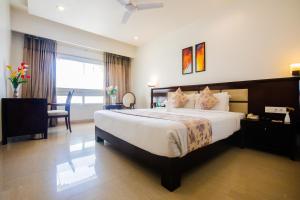 烏代浦的住宿－地平線酒店，一间卧室配有一张床、一张桌子和一把椅子