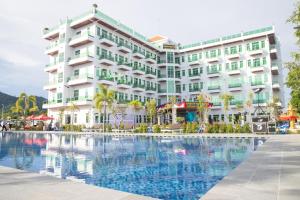 a hotel with a swimming pool in front of a building at Sangkahak Mith Hotel in Kep