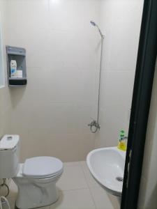 a white bathroom with a toilet and a sink at Durrat Al Israa in Umm el ‘Amad