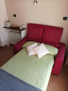 a red bed with two pillows on top of it at Il nido in Alba
