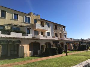 duży budynek z trawnikiem przed nim w obiekcie Sardinia House w mieście Porto San Paolo