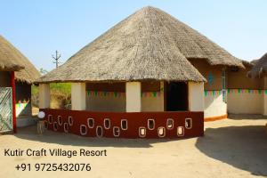 a couple of huts with thatched roofs at Kutir Craft Village Resort in Bherandiāla
