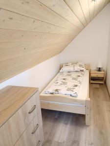 Domki na Zapotocu في Grywałd: غرفة نوم بسرير وسقف خشبي