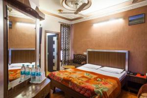 a bedroom with a bed and a desk with bottles of water at Hotel Novelty in Jammu