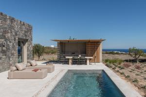 a backyard with a swimming pool and a house at Aesthesis Boutique Villa Trace in Fira