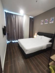 1 dormitorio con cama blanca y ventana en Hotel Mutiara, en Gua Musang