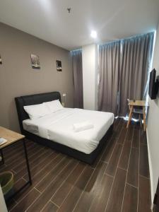 1 dormitorio con 1 cama y suelo de madera en Hotel Mutiara, en Gua Musang