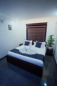 a bedroom with a large bed with a wooden headboard at BEVERLY SUITES in Wayanad
