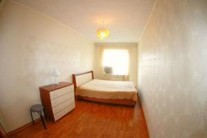 a bedroom with a bed and a dresser and a window at Dekabrist apartment at petrovsko-zavodskaya 31 in Chita