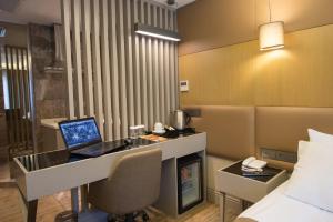 a hotel room with a desk and a laptop on it at GK Regency Suites Hotel in Istanbul