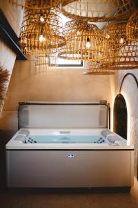 a hot tub in a room with chandeliers at Comme chez Soye - Private Wellness in Soye