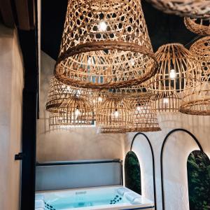 a large chandelier hanging over a tub in a room at Comme chez Soye - Private Wellness in Soye