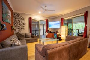 KiteSurf 1770 Beach House في أغنيس ووتر: غرفة معيشة مع كنبتين وتلفزيون بشاشة مسطحة