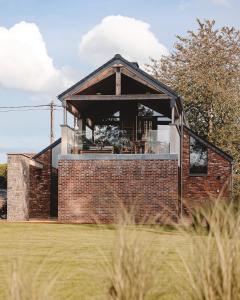 a brick house with a large window at Comme chez Soye - Private Wellness in Soye