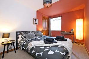 a bedroom with a large bed with orange walls at Sensational West End Living with Bicocca Stays in Aberdeen