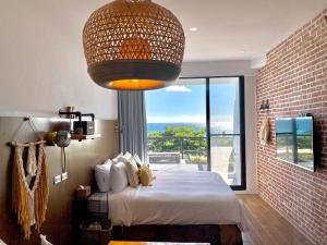 a bedroom with a large bed and a large window at Minimi Inn-Sailrock Beach House in Eluan