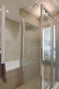 a shower with a glass door in a bathroom at Le Fonctionnel - TravelHome in Villefranche-sur-Saône