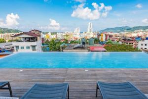a large swimming pool with a view of a city at LullaBella Hotel Patong,Nanai Road in Patong Beach +31 photos