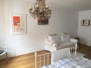un soggiorno con lampadario pendente e divano bianco di Apartment zur schönen Sophie a Gmunden