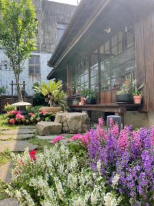 un jardín con flores frente a un edificio en 南庄東村宿舍Nanzhuang Dongchon Homestay en Nanzhuang