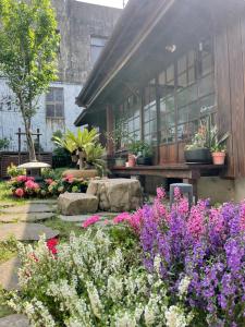 a garden with flowers in front of a building at 南庄東村宿舍Nanzhuang Dongchon Homestay in Nanzhuang
