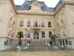 ein großes Gebäude mit einer Uhr darüber in der Unterkunft Le Fonctionnel - TravelHome in Villefranche-sur-Saône