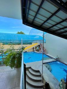 uitzicht op een zwembad vanaf het balkon van een huis bij Weekdays Hotspring Resort by Cocotel in Calamba