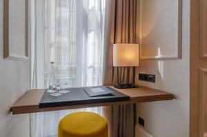 a room with a desk with a lamp and a yellow stool at Eurostars Lisboa Baixa in Lisbon