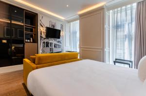 a hotel room with a bed and a yellow couch at Eurostars Lisboa Baixa in Lisbon