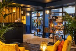 una tienda con paredes azules y muebles y plantas amarillos en Welcome Hotel en París