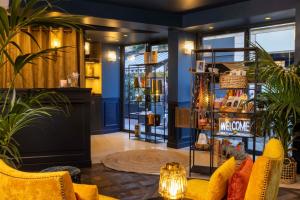 ein Geschäft mit blauen Wänden, gelben Möbeln und Pflanzen in der Unterkunft Welcome Hotel in Paris