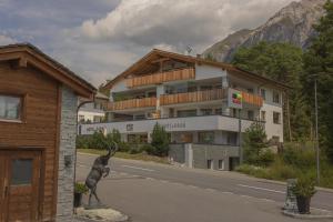 ein Gebäude mit einer Statue vor einer Straße in der Unterkunft Hotel Sarain Active Mountain Resort in Lenzerheide