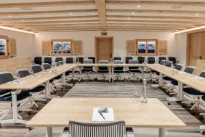 a large conference room with wooden tables and chairs at Hotel Sarain - Val Saraina Resort Lenzerheide in Lenz