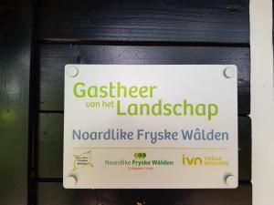 a sign on a door with a sign for a garage at Natuurhuisje 't Poepekrus in Kootstertille