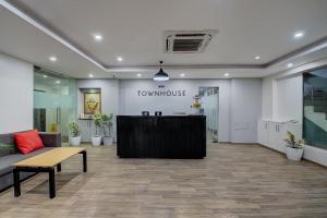 eine Lobby eines Stadthauses mit einer Bank und einem Schreibtisch in der Unterkunft Hotel Unicontinental in Mumbai