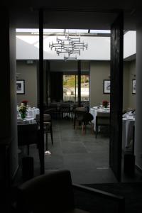 een eetkamer met witte tafels en een kroonluchter bij Hotel Blanc in Marigny-Saint-Marcel