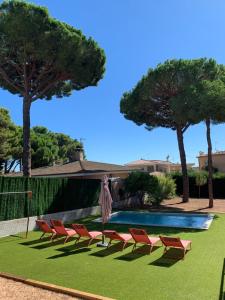 un grupo de sillas y una piscina en Costa Brava Villa en Platja  d'Aro