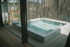 eine Badewanne im Inneren eines Fensters in der Unterkunft SNOW PEAK FIELD SUITE SPA HEADQUARTERS 