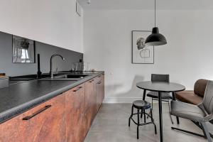 a kitchen with a sink and a table with chairs at Downtown Apartments Aura III in Gdańsk