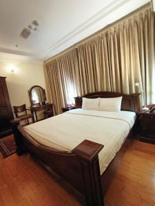 a bedroom with a large bed with white sheets at Al Khariss Hotel in Doha