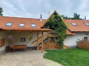 ein Haus mit einer Bank im Hof in der Unterkunft Apartmán na farmě u koní in Milešov