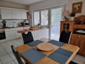 eine Küche mit einem Holztisch sowie einem Tisch und Stühlen in der Unterkunft Ferienwohnung Mohnblume 