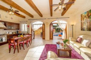 een keuken en een woonkamer met een bank en een tafel bij Rebbiegha Holiday Home in Qala