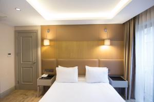 Postel nebo postele na pokoji v ubytování GK Regency Suites Hotel