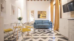 a living room with a blue chair and a table at Virgen Blanca - Apartamentos Aloha Toledo in Toledo