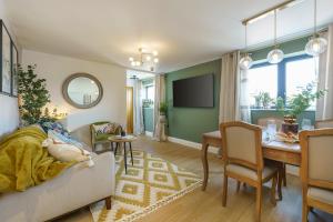 Evergreen - 2 Bed Luxury Apartment by Mint Stays في بريستول: غرفة معيشة مع طاولة وغرفة طعام