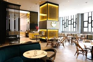 a restaurant with tables and chairs and a kitchen at 92 Homestay 3 Bedrooms Midhills Genting Highland in Genting Highlands