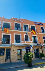 a hotel with flags flying in front of it at Hostal L'Anfora in Denia