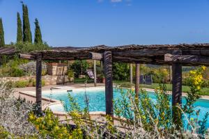 una piscina con pérgola de madera y una piscina en Il Cortile, en Civitella Marittima
