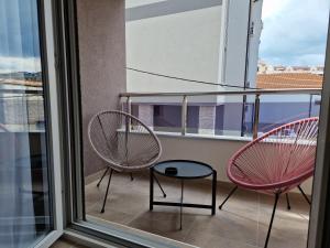 2 stoelen en een tafel op een balkon bij PRONTO apartman & PRONTO studios in Kruševac